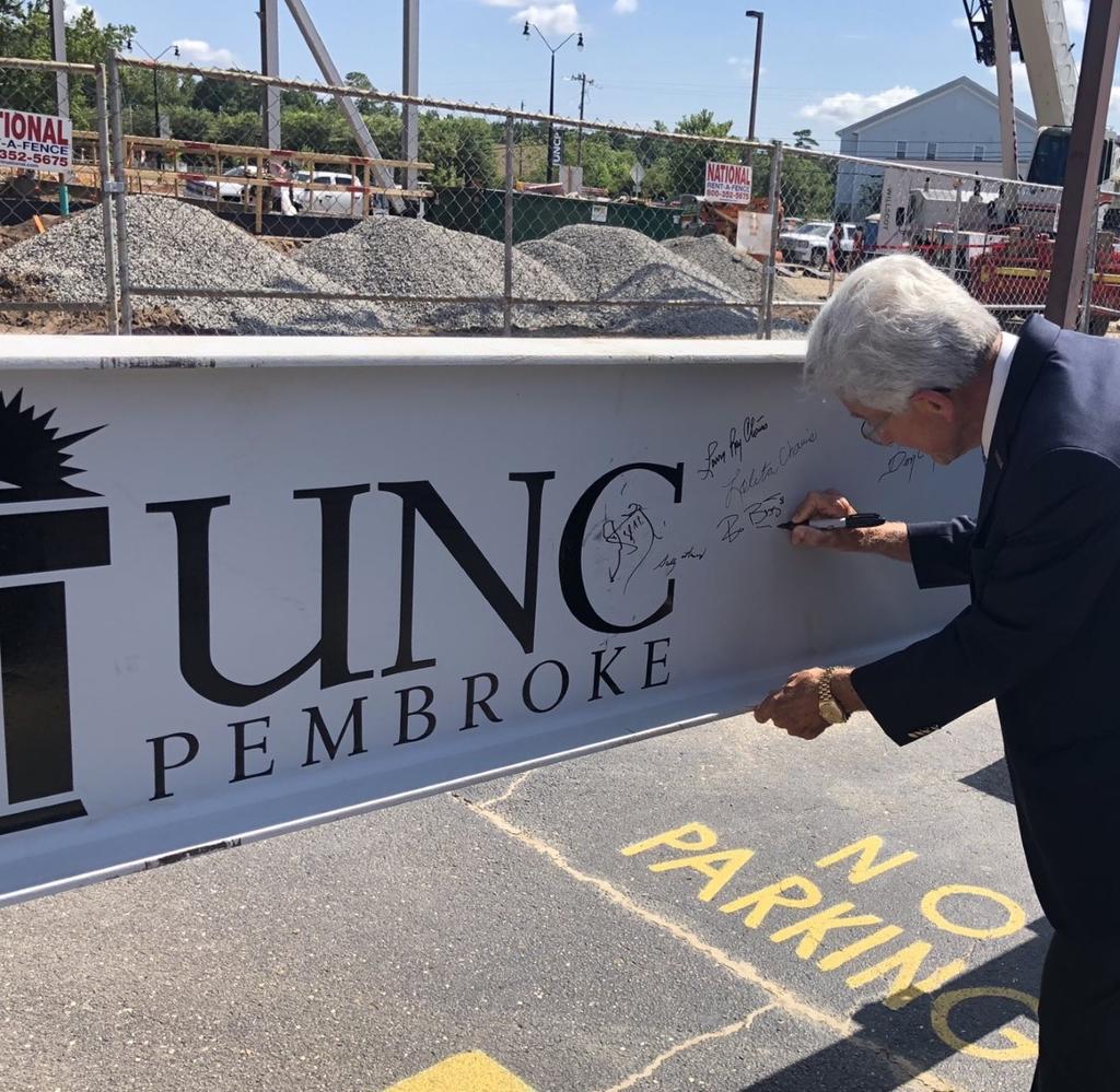 Bo Biggs, chairman of the Golden LEAF Foundation, signs the final beam at the topping out ceremony on July 23, 2020