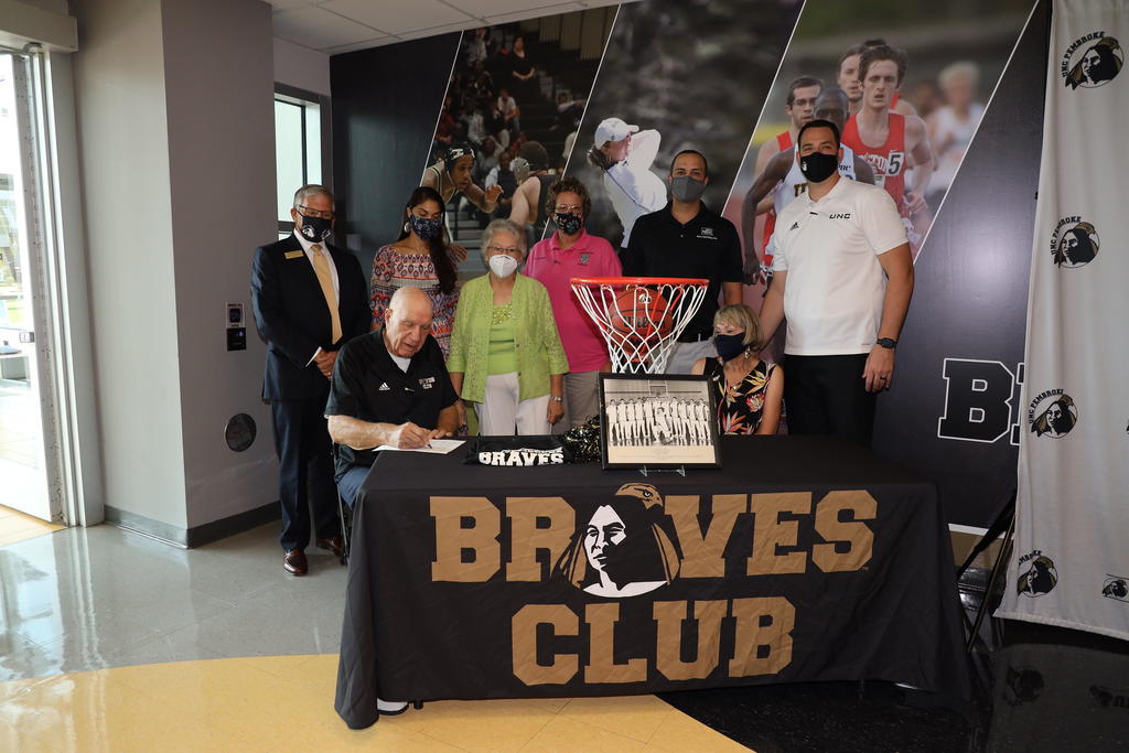 Eddie Mac Locklear (seated) attends a signing event with Panthia Locklear. Chancellor Robin Gary Cummings (left) attended along with Autumn Locklear, Polly Locklear, Gerri Locklear, Garrick Locklear and Men's Head coach Drew Richards