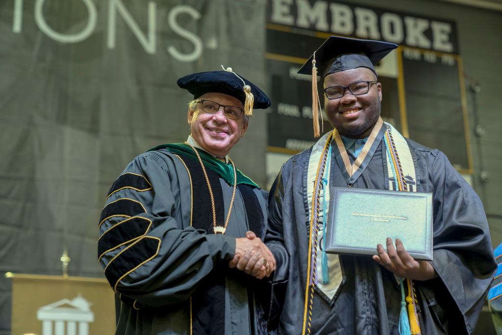 Devin Green shakes hands with Chancellor Cummings after receiving his diploma