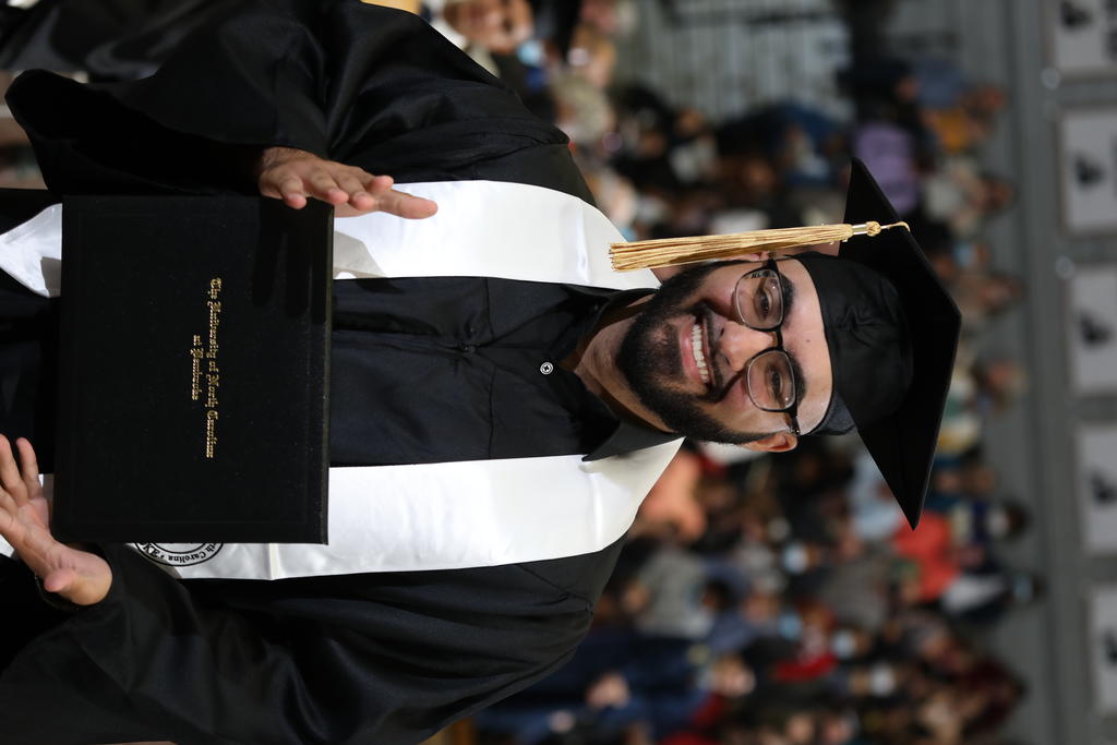Ahmad Aziz poses with his diploma after crossing the stage during Winter Commencement at UNCP on Saturday, December 11, 2021