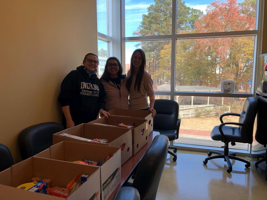 Drs. Renee Lamphere, Lauren Norman, and Corey Pomykacz work together on a food drive for students.