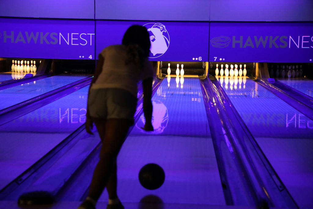 Woman releasing bowling ball on lane in Hawks Nest.