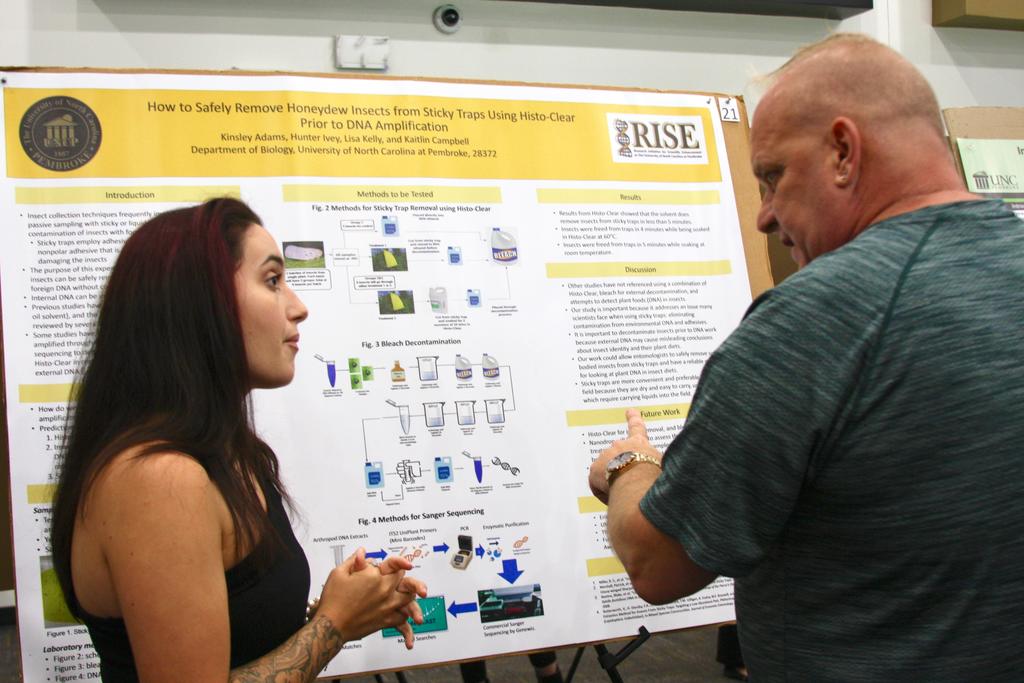 Kinsley Adams (left) discusses her research with Dr. Timothy Anderson