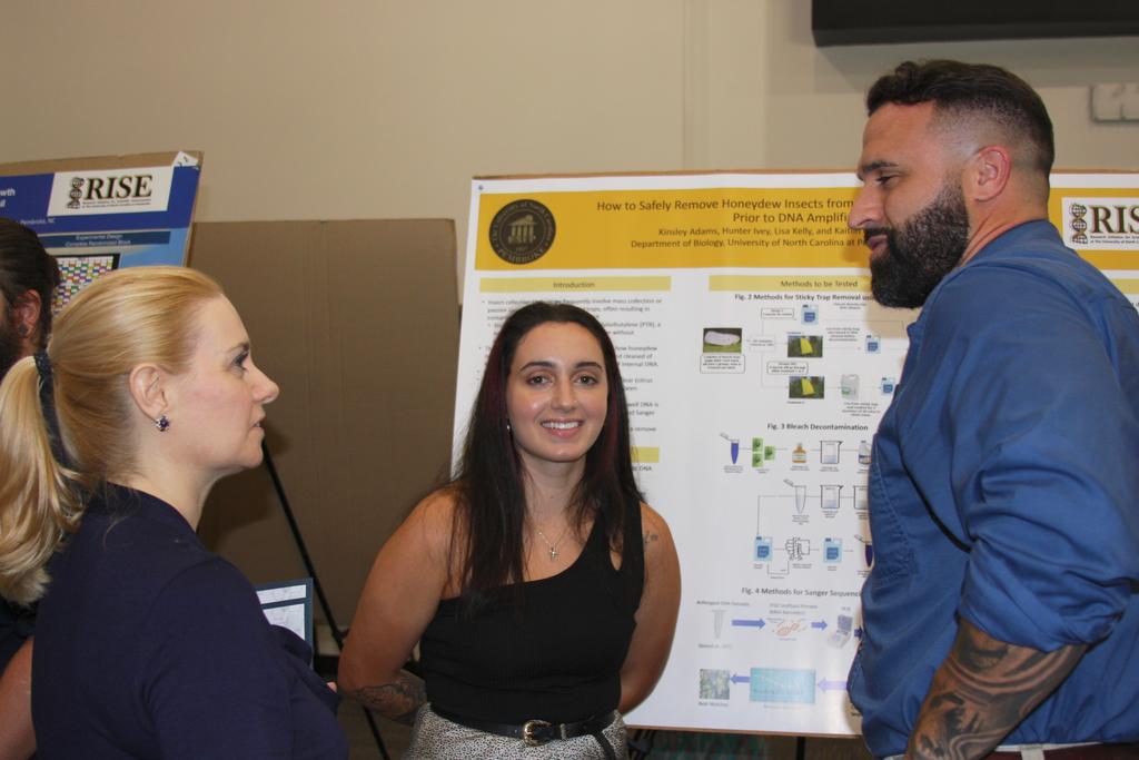 Dr. Rachel Smith (left), Kinsley Adams (middle), and Kinsley's brother (UNCP alumnus) chat during the poster presentation