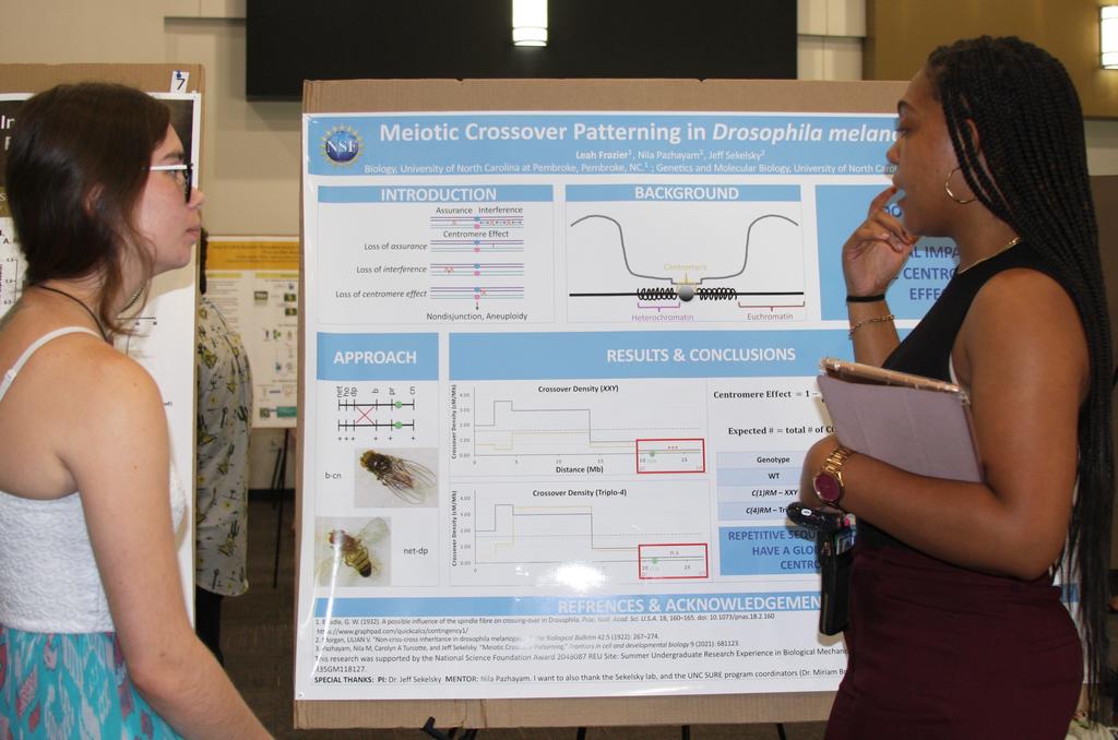 Ashley Edwards (left) and Leah Frazier chat in front of Leah's research poster
