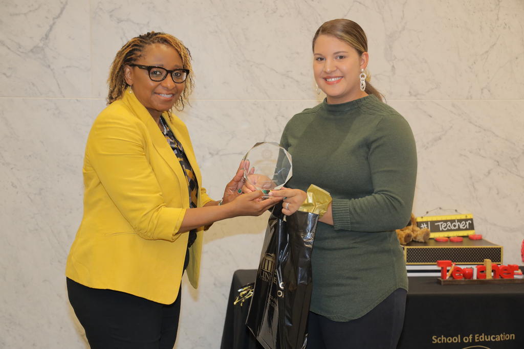 Dean Loury Floyd presents the Student Teacher of the Year Award to Morgan Jones during the School of Education pinning ceremony on December 9, 2022