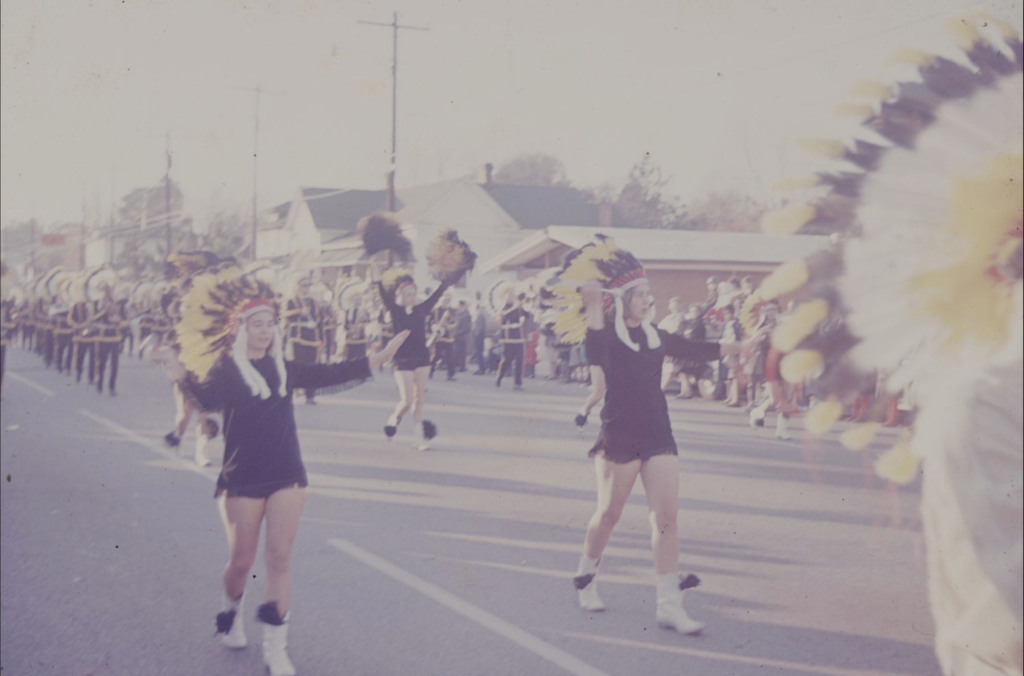 The band marching in a parade during the 1970s