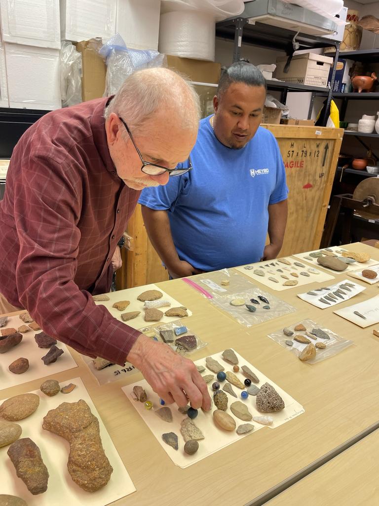 State Archaeologist John Mintz (left) examines artifacts collected by UNCP senior Harlen Chavis (right)