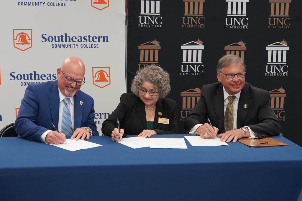 Southeastern Community College President Chris English (far left) signs a cybersecurity articulation agreement with interim Provost Dr. Cherry Maynor Beasley and Chancellor Robin Gary Cummings during a ceremony at SCC on April 28, 2023