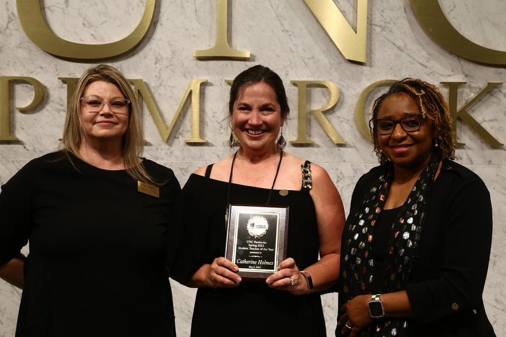 Diana Parnell, left, and Dean Loury Floyd, right, presents Catherine Holmes with the 2023 Student Teacher of the Year Award