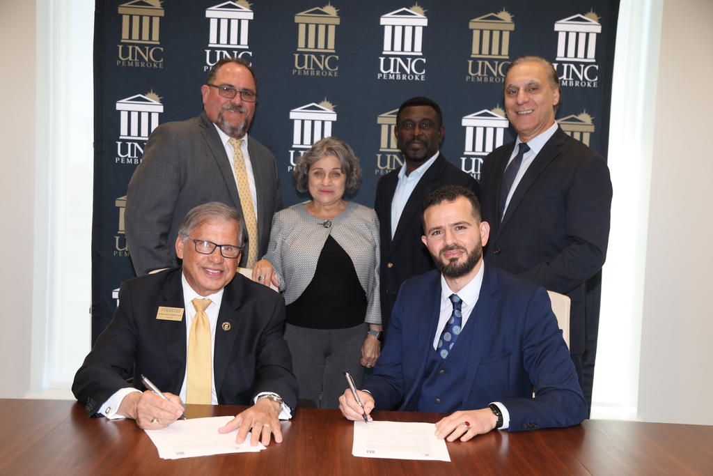 Chancellor Robin Gary Cummings and Dr. Oussama Ammar (seated) with Assistant ProfessorScott Cohen, Interim Provost Cherry Beasley, Associate Dean Cliff Mensah and Dr. Mohamed Djerdjouri, dean of the Thomas College of Business and Economics