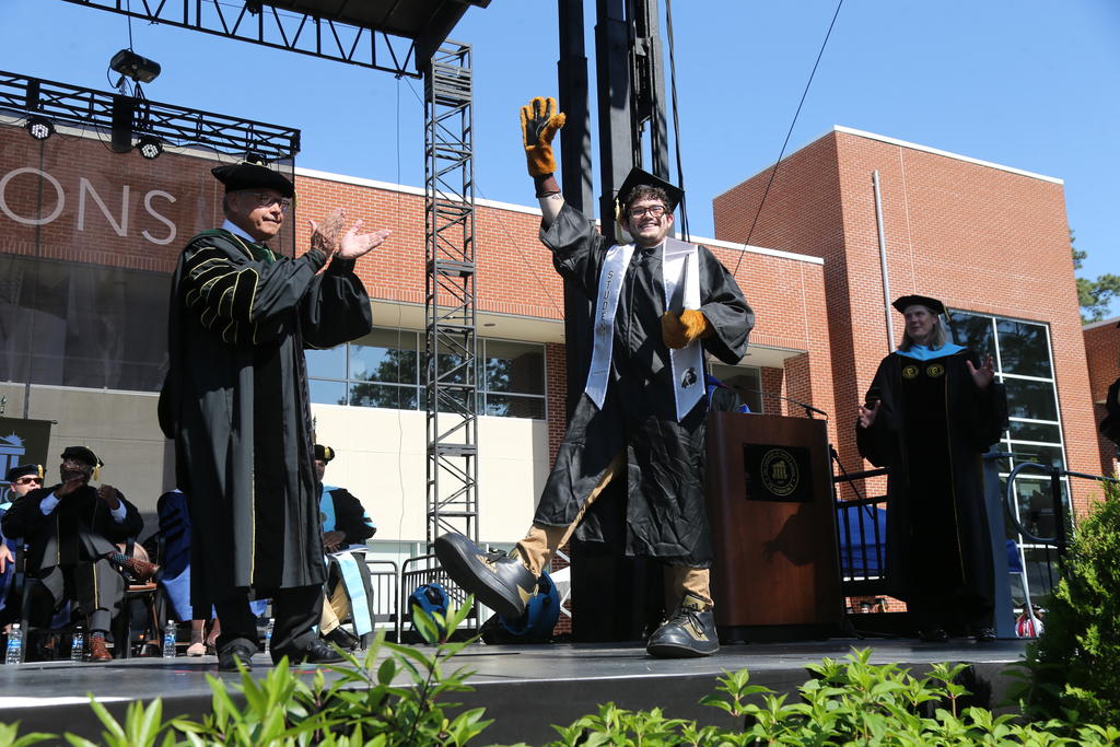 Zane Fink aka Brave Hawk cross the stage during spring commencement on May 6, 2023