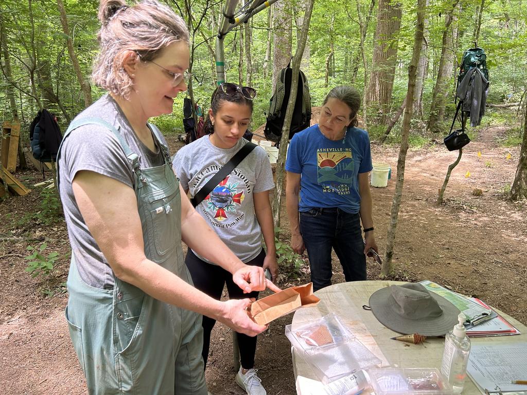 Rakyah Jacobs, middle, visits with the Research Laboratories of Archaeology at UNC-Chapel Hill's Field School at an archaeological dig in Duke Forest