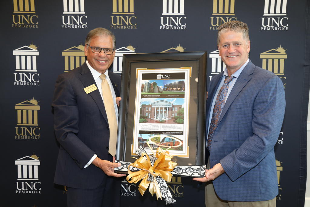 UNCP Chancellor Robin Gary Cummings presents Blair Fisher, Head of School, with a gift during a private luncheon on July 25, 2023