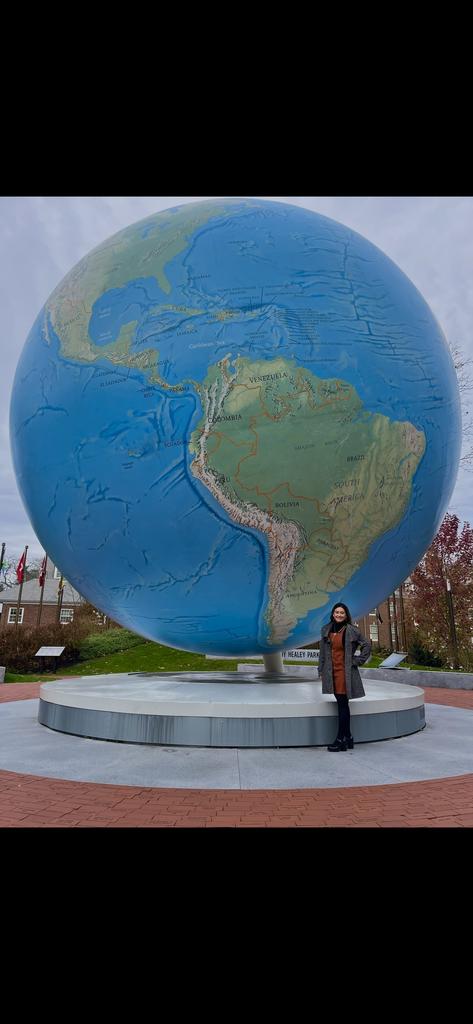 Teresa Fernandez poses in front of the Babson World Globe at Babson College