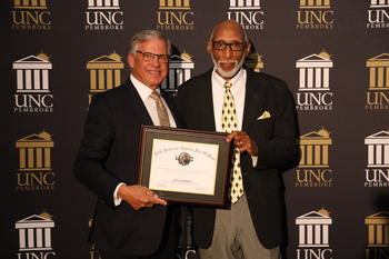 Chancellor Robin Gary Cummings presents a plaque Larry Rodgers recognizing his induction into Class of 2020 Hall of Fame